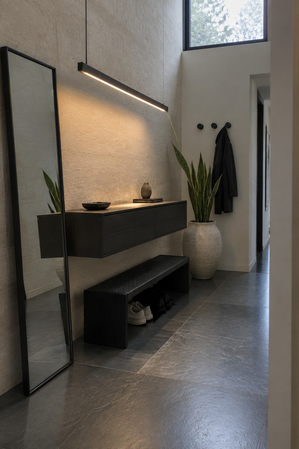 Modern minimalist entryway with floating console, bench, mirror, plant, and coat hooks.