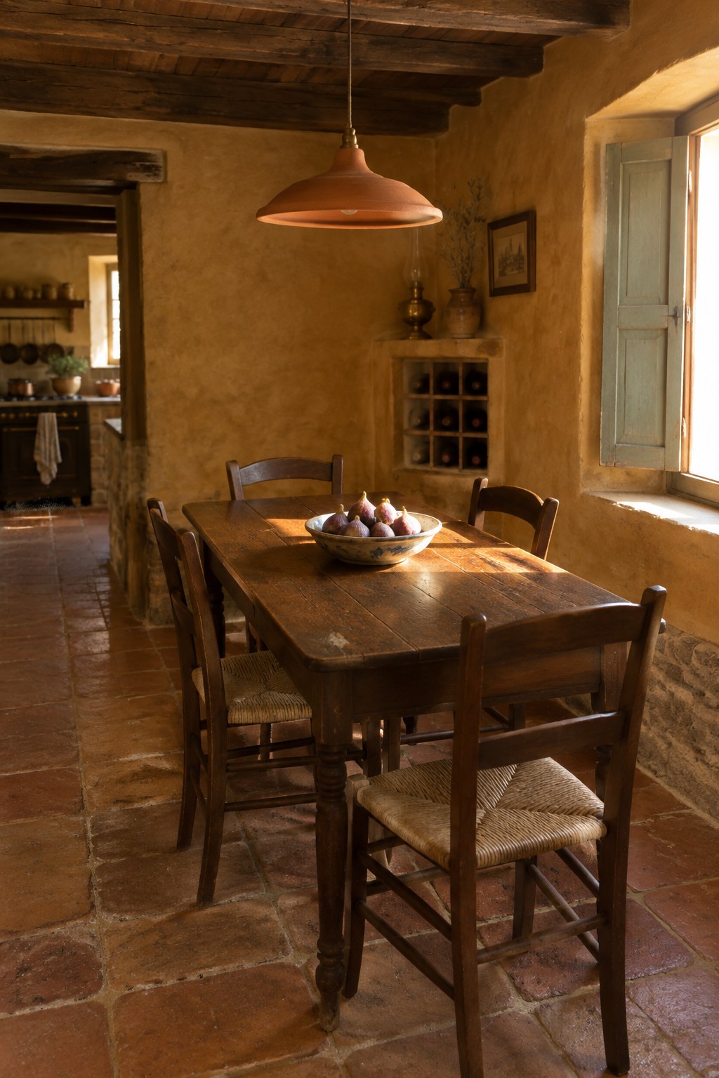 Rustic wooden dining table with fig bowl in sunlit terracotta room