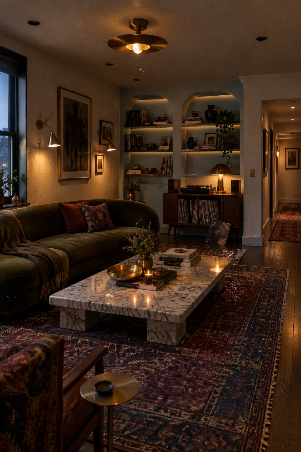Cozy living room with green velvet sofa, marble coffee table, arched bookshelves, and patterned rugs.